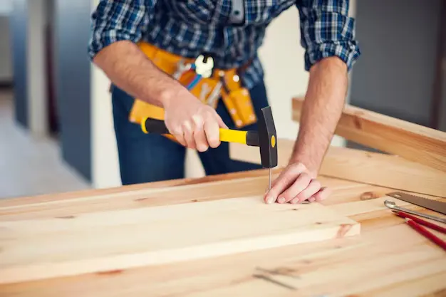 close-up-man-hitting-nail-by-hammer_329181-3740