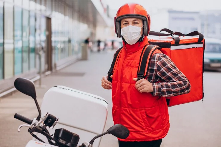 food-delivery-boy-driving-scooter-with-box-with-food-wearing-mask_1303-27713